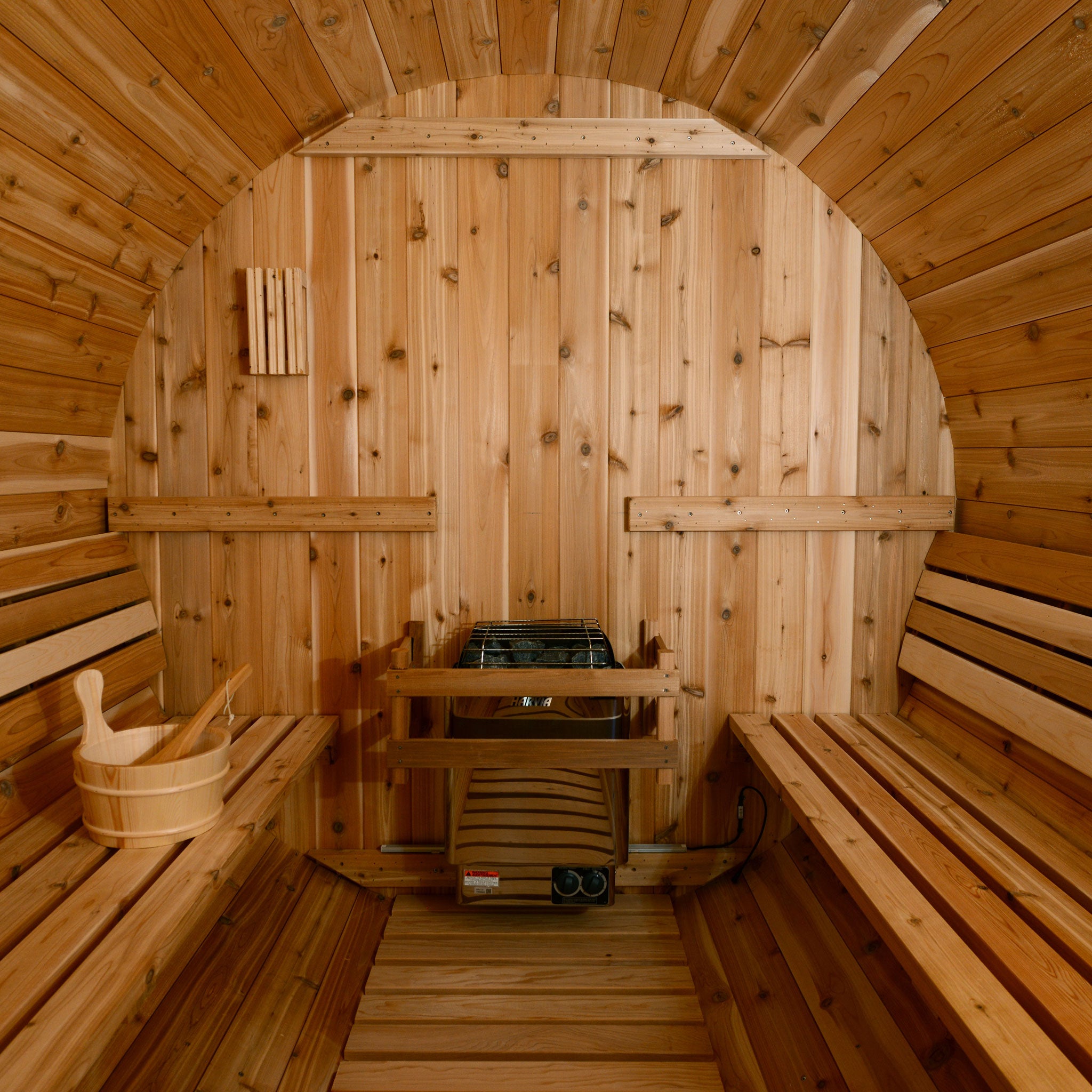 Barrel sauna interior featuring Harvia heater.